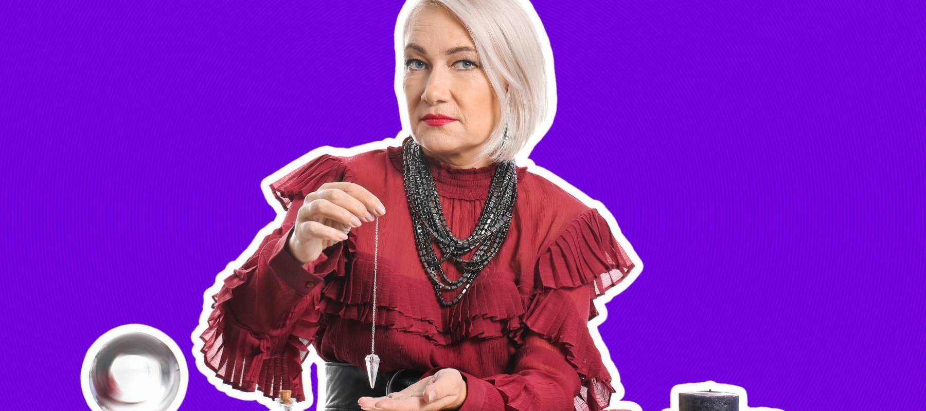 an older woman dressed like a fortune teller, holding a crystal pendulum out in front of her