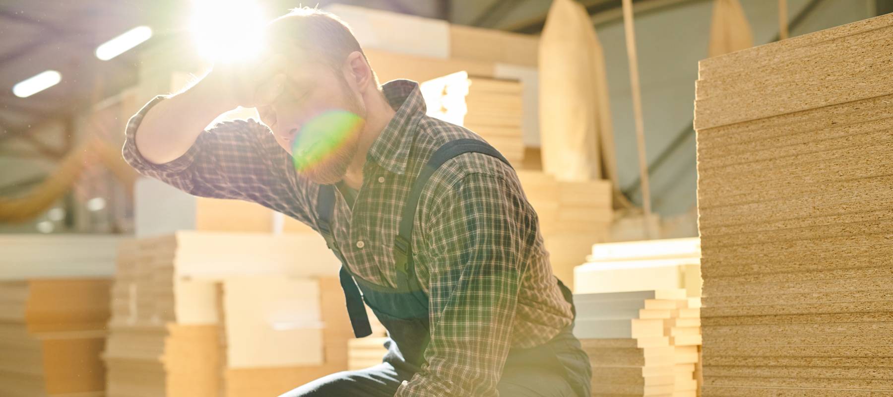 An exhauster worker wipes sweat from their forehoead.