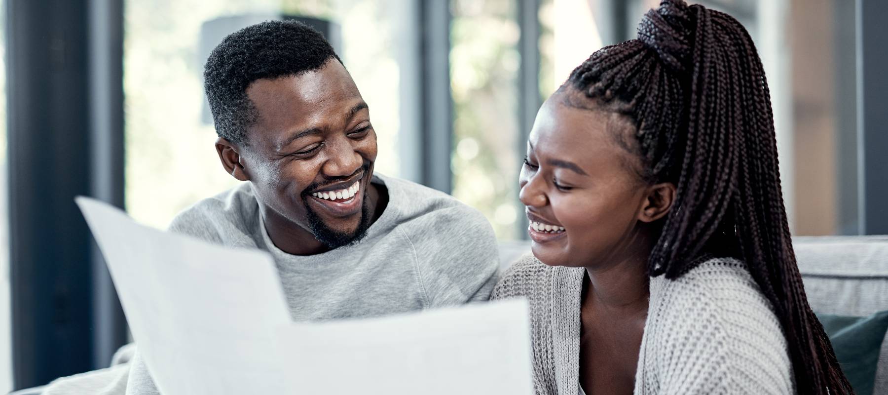 Home, black couple and happy with paperwork on sofa for finance plan or interest rate on loan application.