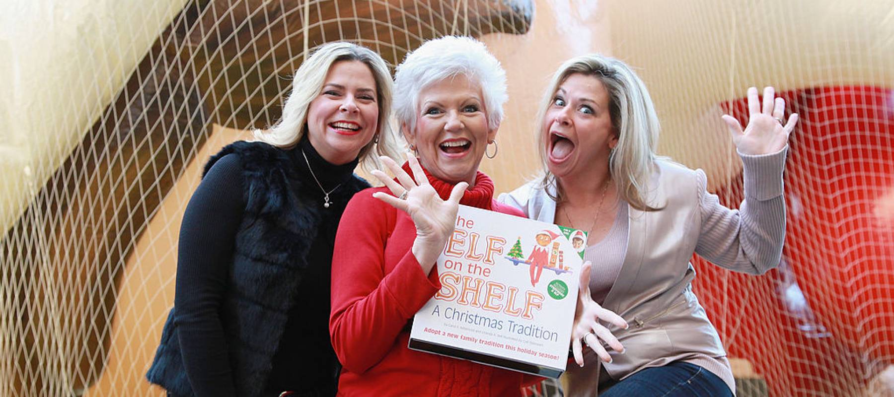 Twin sisters Chanda Bell and Christa Pitts celebrate with their mother, "The Elf on the Shelf" co-author Carol Aebersold in 2012.