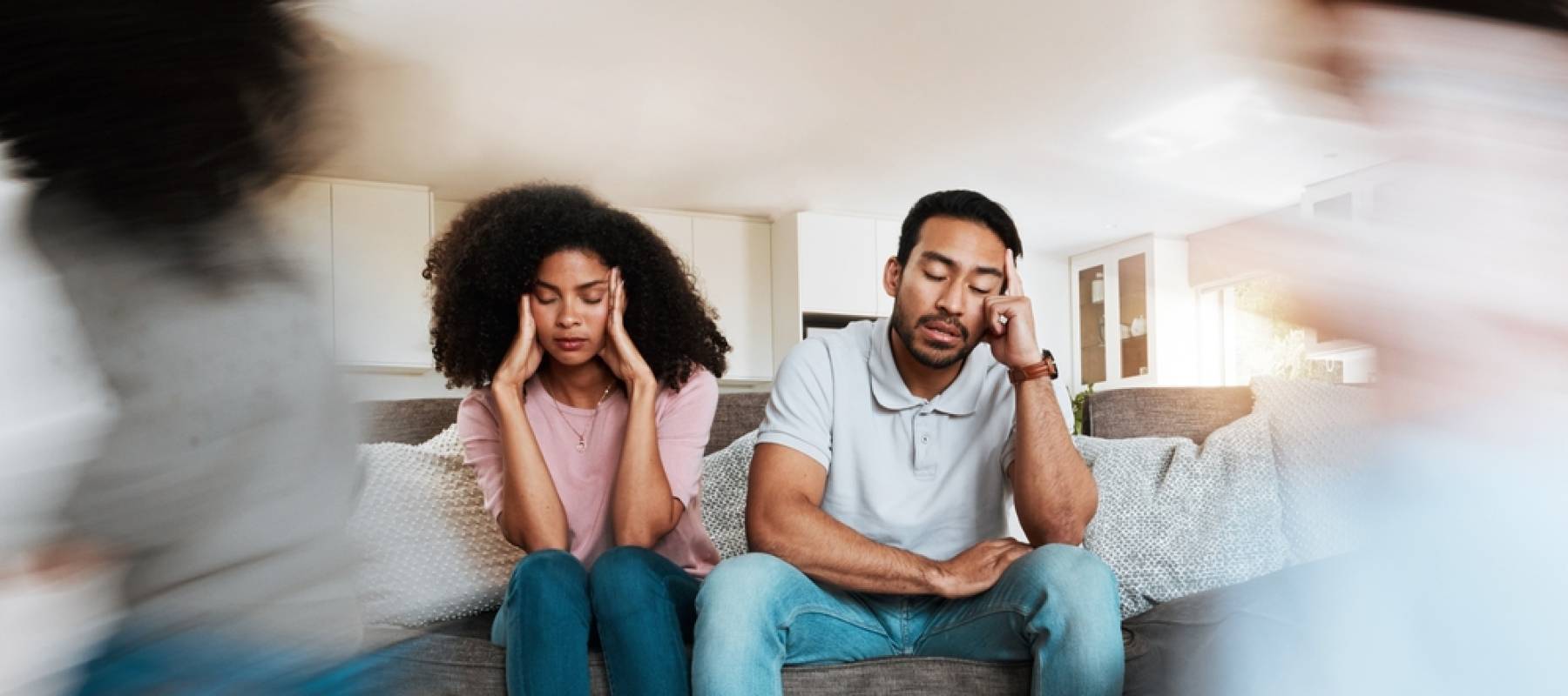 kids running with stressed parents on the sofa