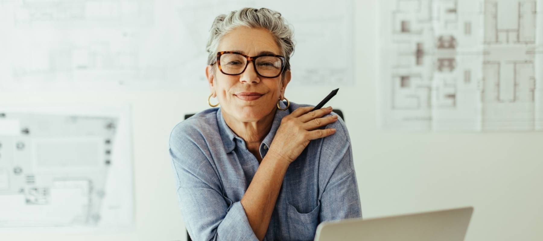 mature female designer looks at the camera in her office, confident in her expertise