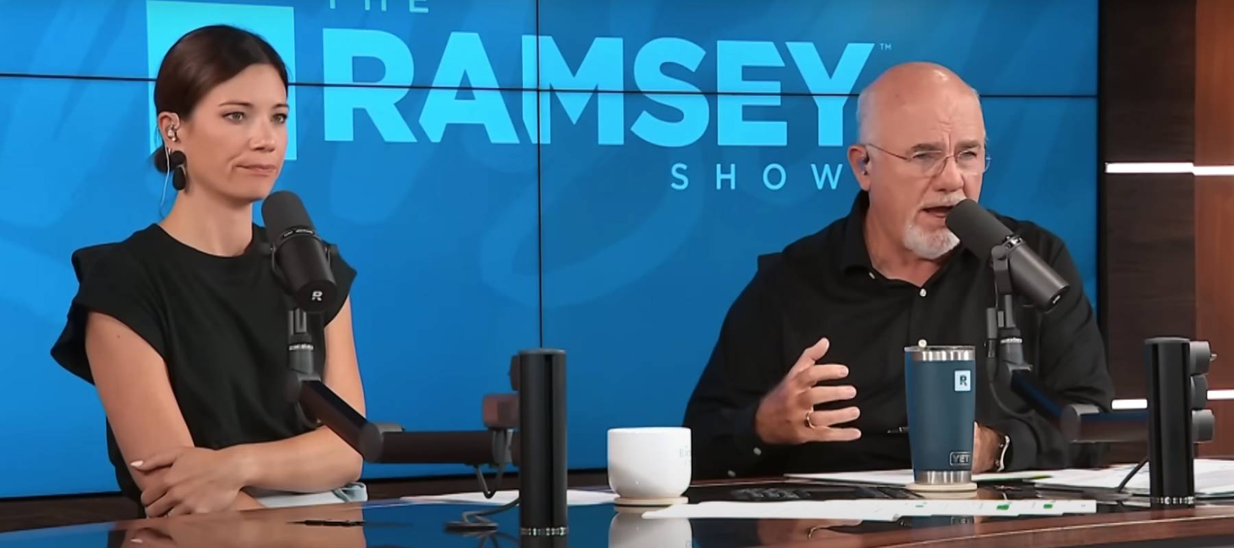 Rachel Cruz and Dave Ramsey sit on set of the Ramsey Show podcast, looking exasperated.