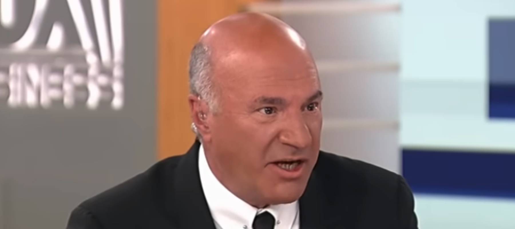 Kevin O&#039;Leary seen on set of Fox Business, looking to the side of the camera in the middle of speaking.