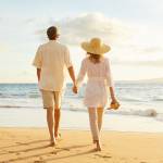 Happy Romantic Middle Aged Couple Enjoying Beautiful Sunset Walk on the Beach. Travel Vacation Retirement Lifestyle Concept