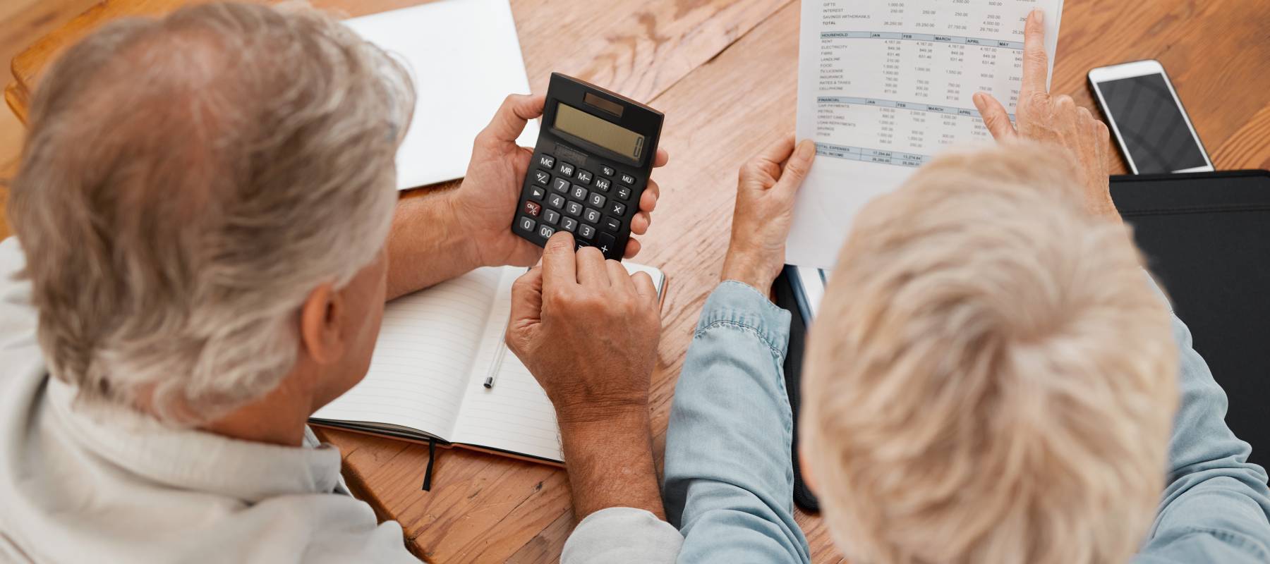 An older couple sit down and go over their finances.