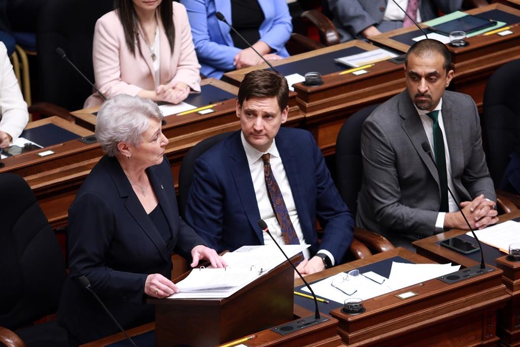 Finance Minister Katrine Conroy tables the budget as Premier David Eby and housing minister Ravi Kahlon look from the legislative assembly at the legislature in Victoria, Thursday, Feb. 22, 2