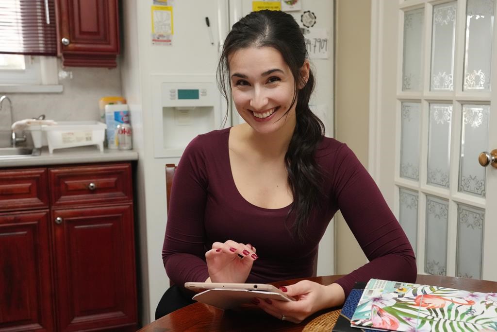 Diana Skakavac scrolls through her iPad in the kitchen of her grandparents&#039; home in Toronto on Wednesday, Feb.21, 2023. Skakavac is behind the @havecouponswilltravel Instagram account. 