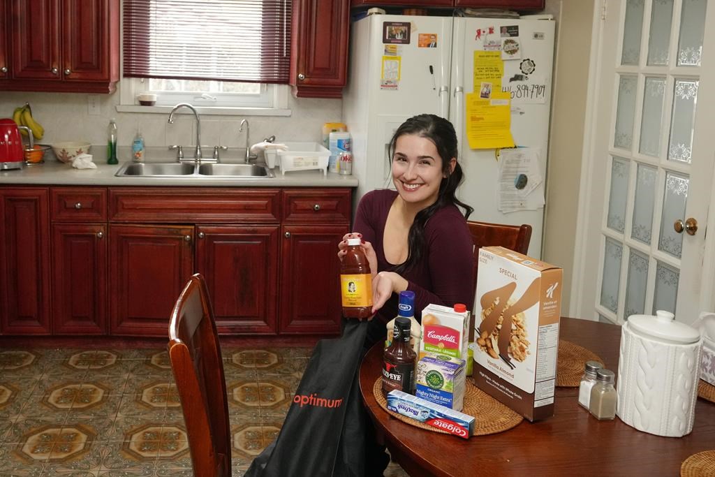Diana Skakavac unpacks groceries in the kitchen of her grandparents&#039; home in Toronto on Wednesday, Feb.21, 2023. Skakavac is behind the @havecouponswilltravel Instagram account. 