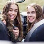 Teenage girl shows off brand new car key and car to her friend