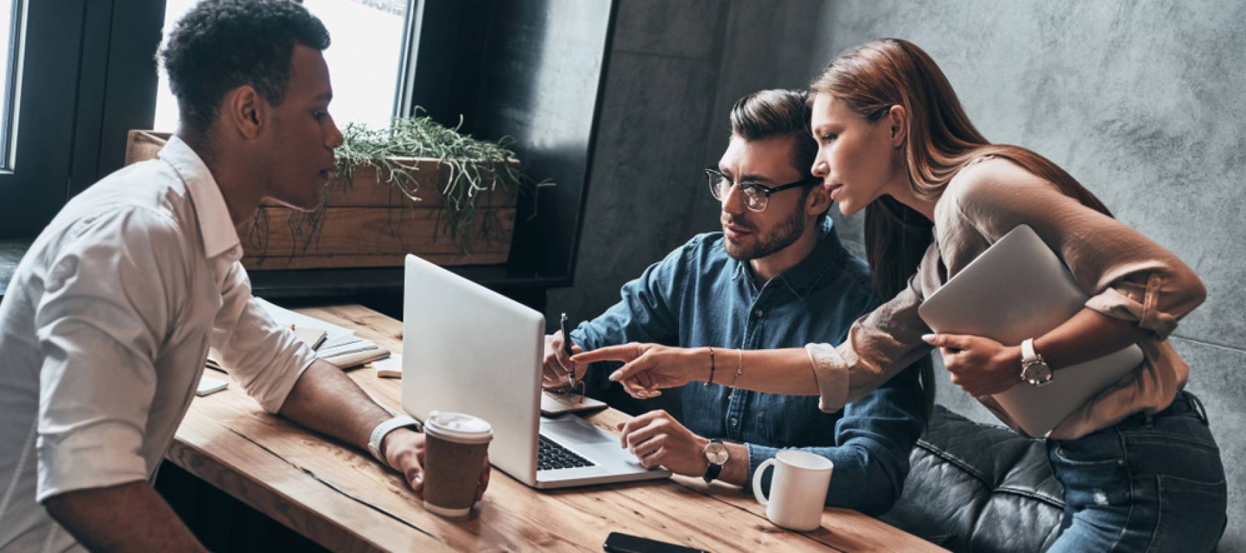 Three young professionals discuss strategy