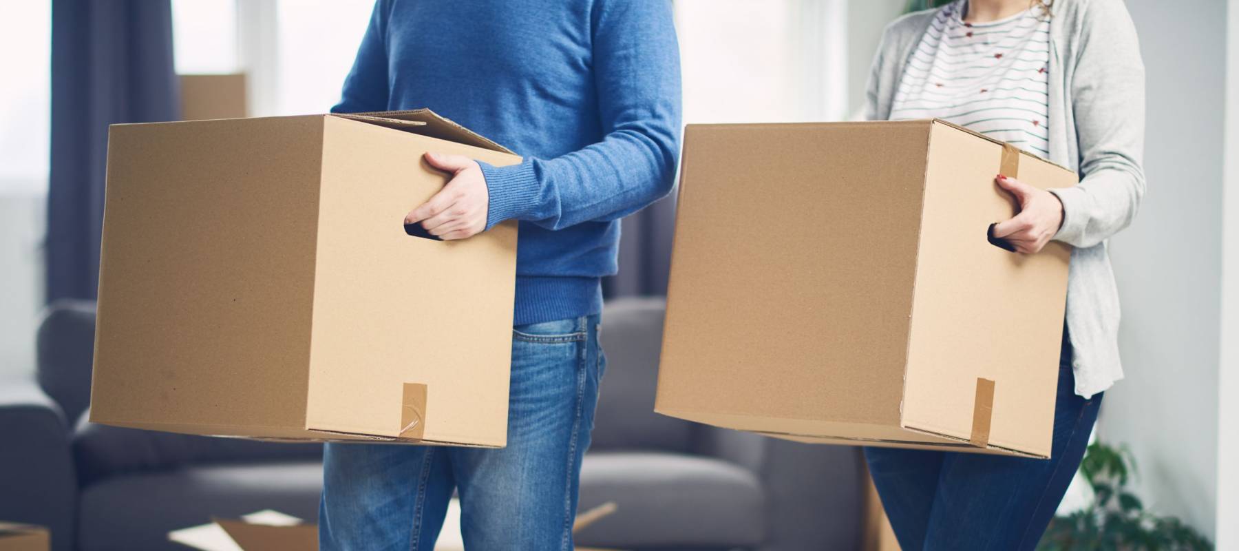 Couple moving into new apartment. Lot of packing cartons around them.