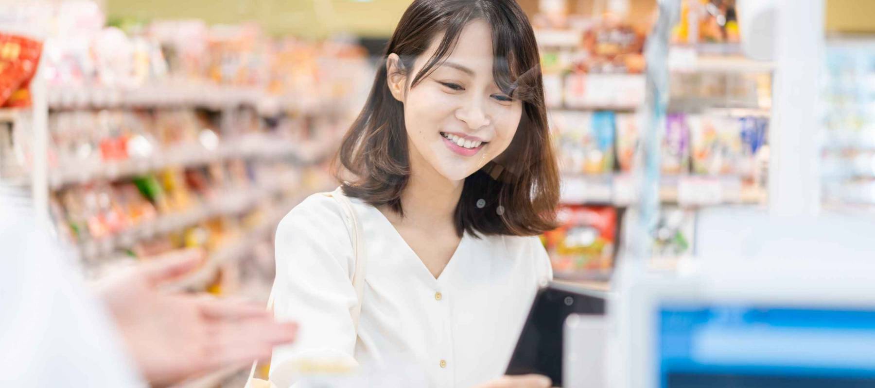 Young woman using self-checkout and e-money payment