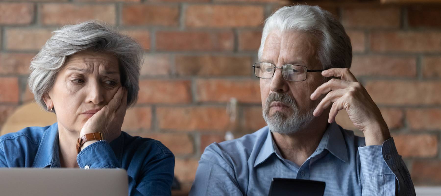 Unhappy mature couple checking financial documents