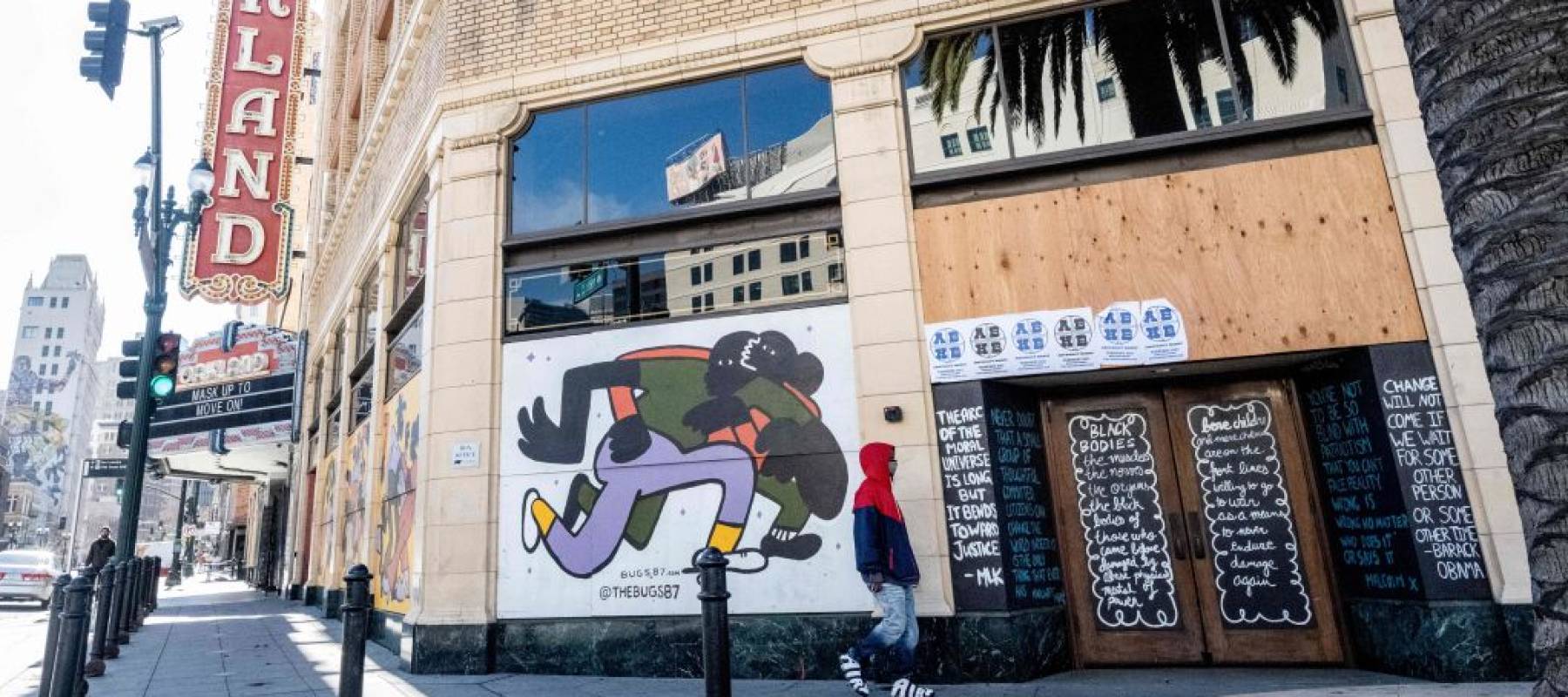 A person walks by a boarded-up shop in Oakland, California.