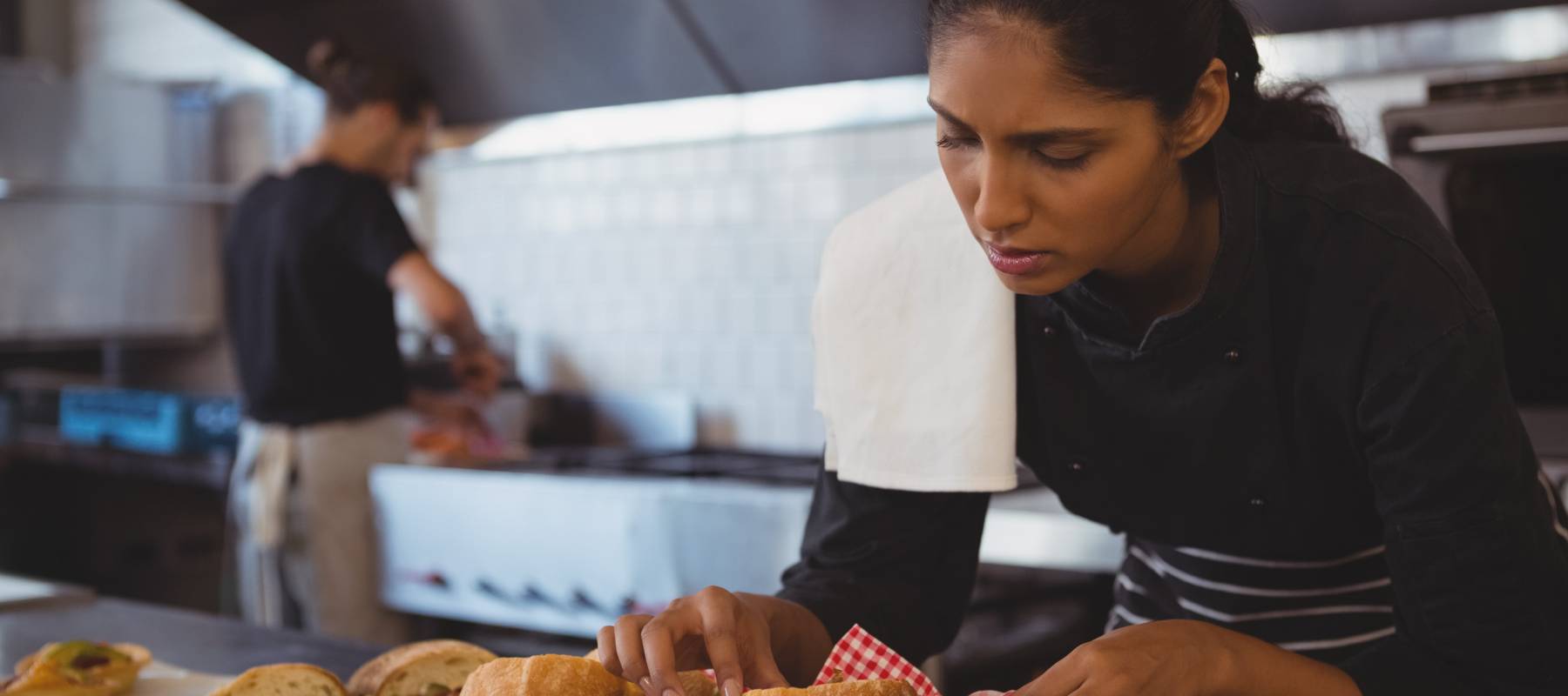 A woman arranges baskets of food.