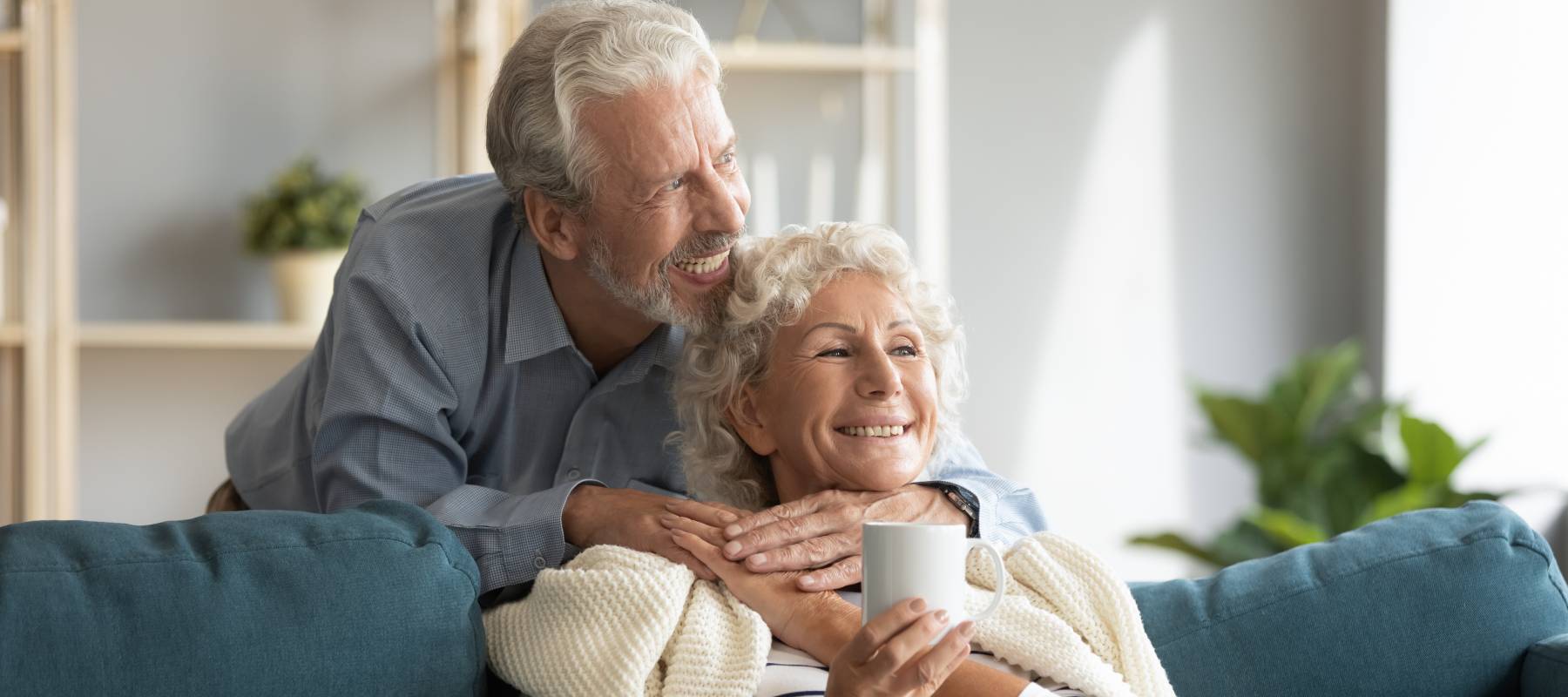 Affectionate senior couple enjoying cozy moment on a couch.