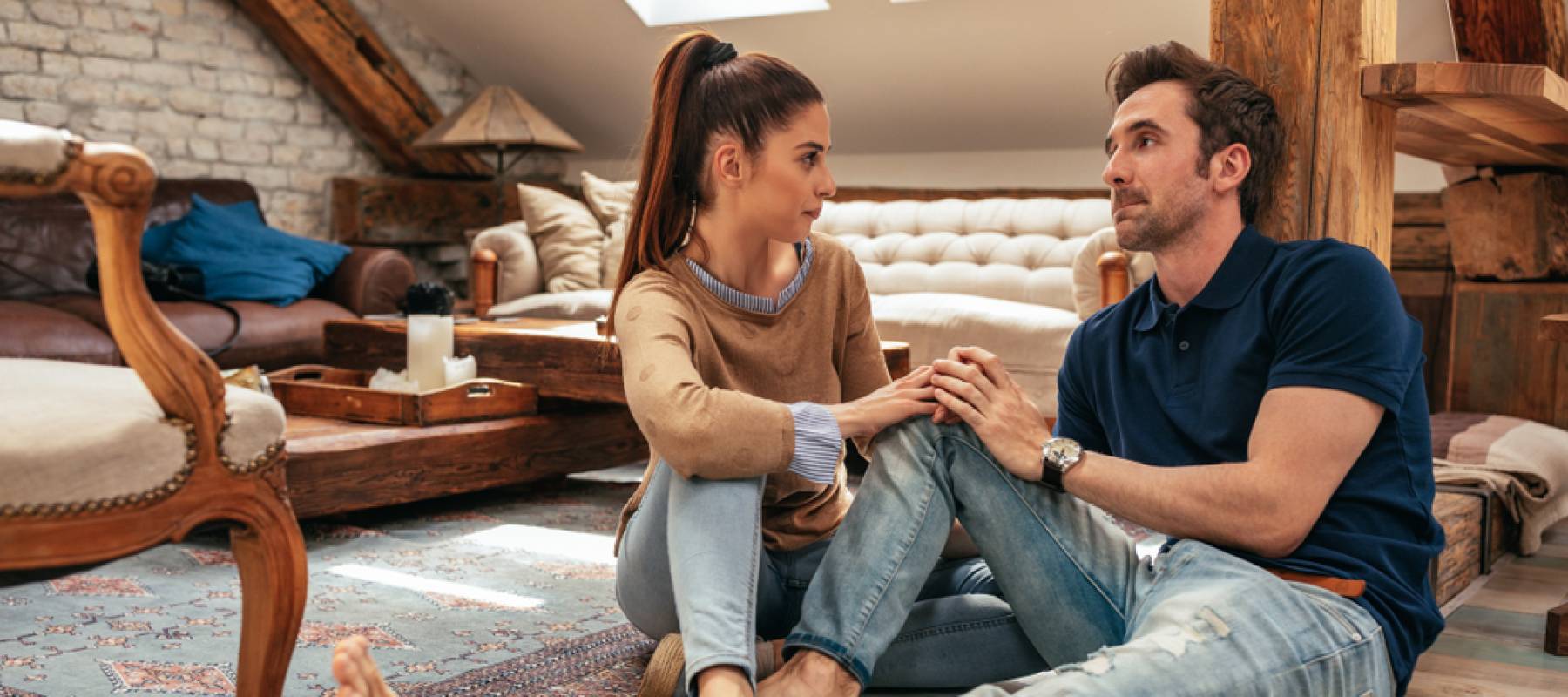 young Caucasian millennial couple sitting on the floor of their apartment