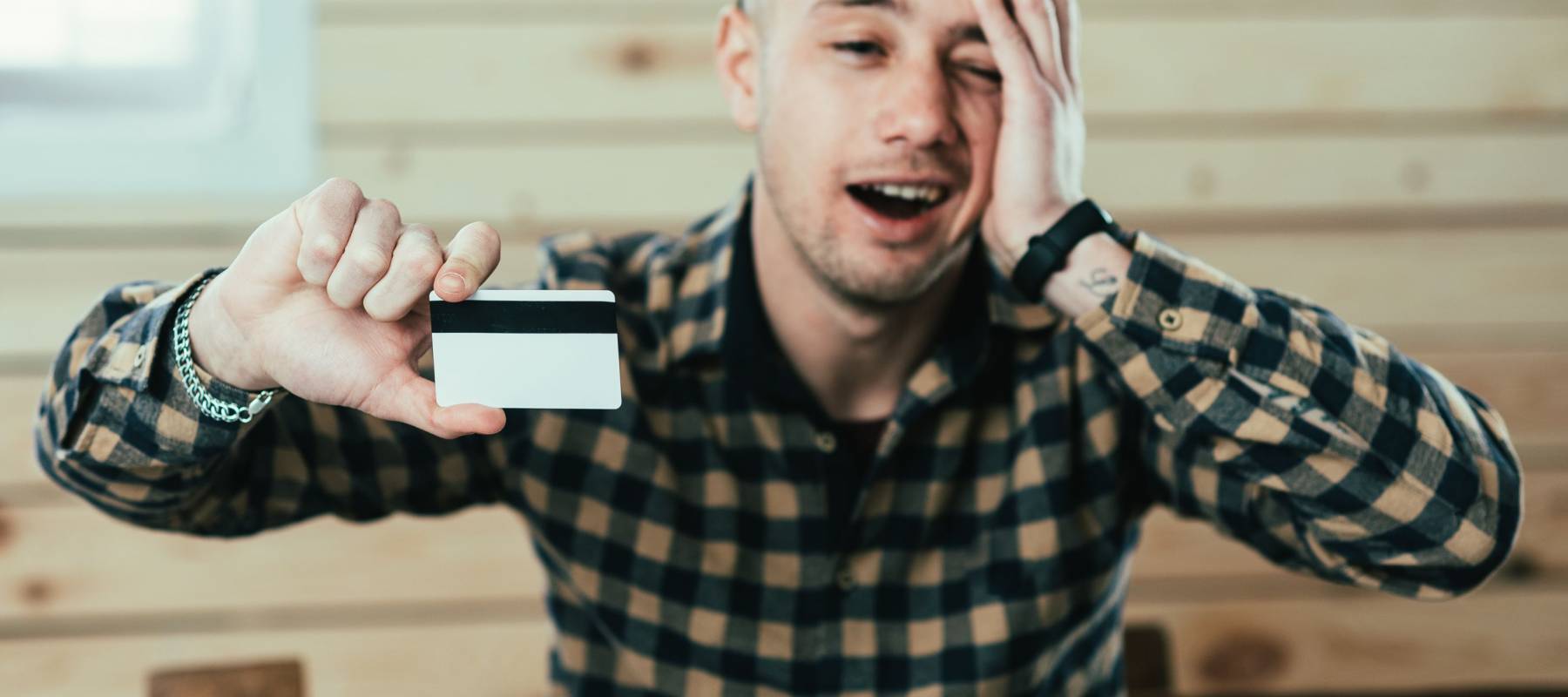 man with credit card white template for insert, on wooden background