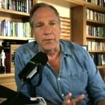 Mike Rowe seen in his home office, speaking into a microphone during television interivew.