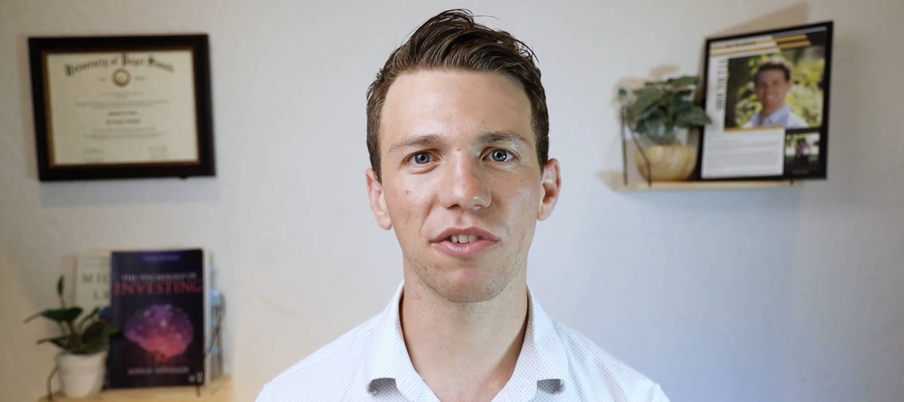 Young man seen talking directly to camera from home office.