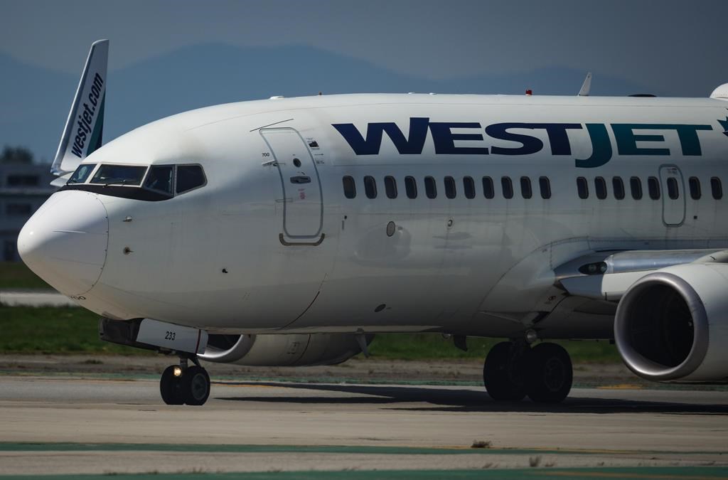 Pilots taxi a WestJet Boeing 737-700 aircraft to the runway for departure from Vancouver International Airport, in Richmond, B.C., on Friday, May 19, 2023. The union representing WestJet Enco