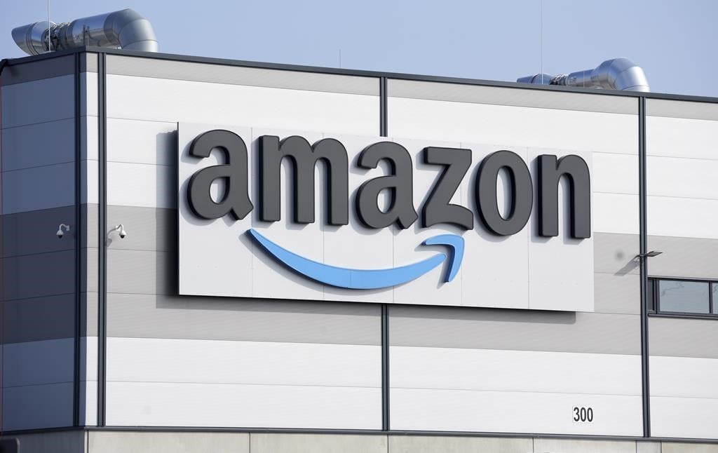 An Amazon company logo is seen on the facade of a company&#039;s building in Schoenefeld near Berlin, Germany, on March 18, 2022. Unifor says it&amp;rsquo;s temporarily withdrawing its applications to