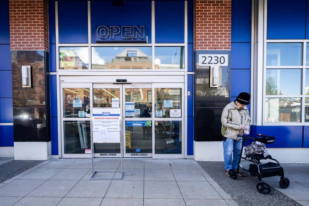 A woman waits outside of the London Drugs Broadway and Vine location in Vancouver on Monday, April 29, 2024. London Drugs is investigating the extent to which data may have been compromised i