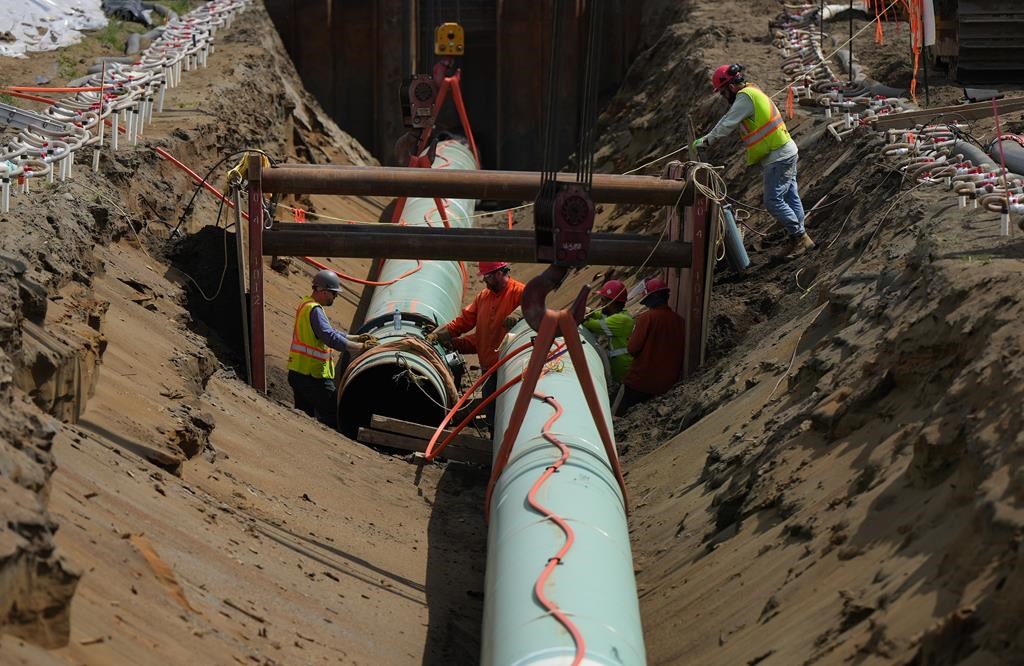Workers lay pipe during construction of the Trans Mountain pipeline in Abbotsford, B.C., on Wednesday, May 3, 2023. 
