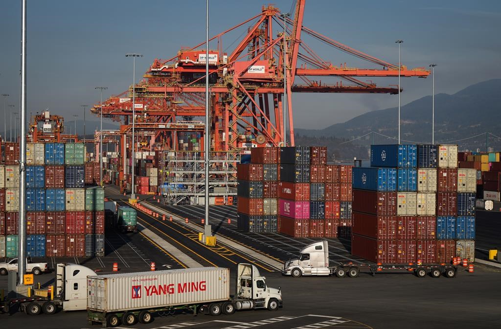 Statistics Canada says the country posted a merchandise trade deficit of $2.3 billion in March. A truck carries a cargo container at the Port of Vancouver Centerm container terminal in Vancou