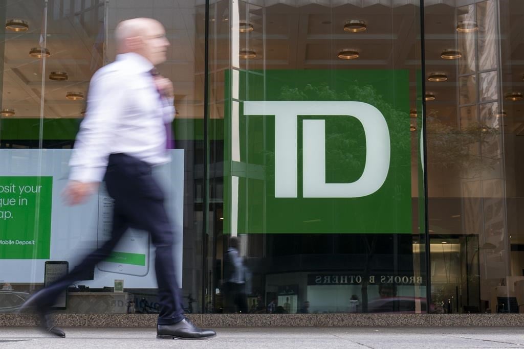 A person makes their way past a Toronto-Dominion Bank in the Financial District of Toronto on August 14, 2023. 