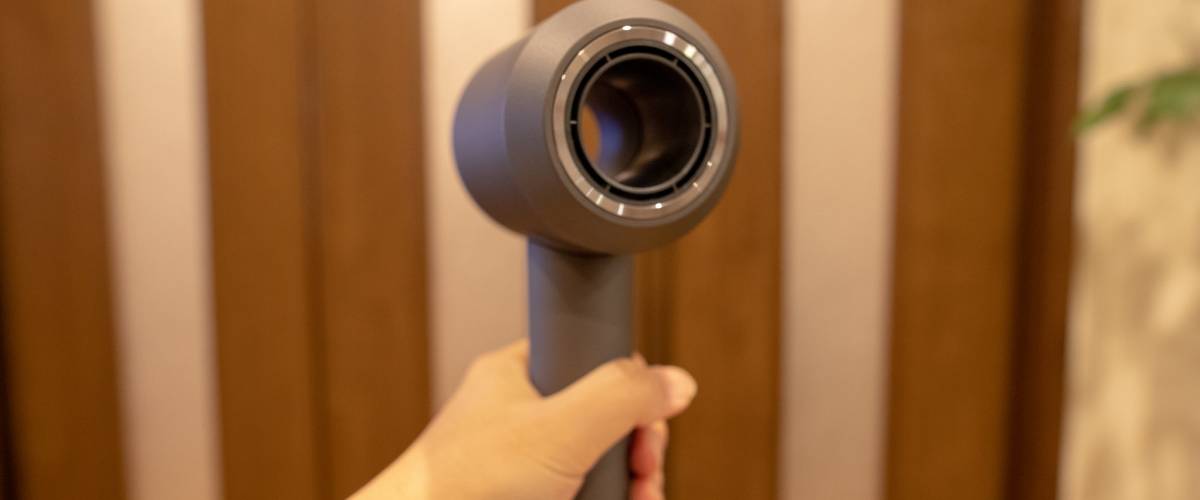 Hand holding a Dyson Supersonic hair dryer
