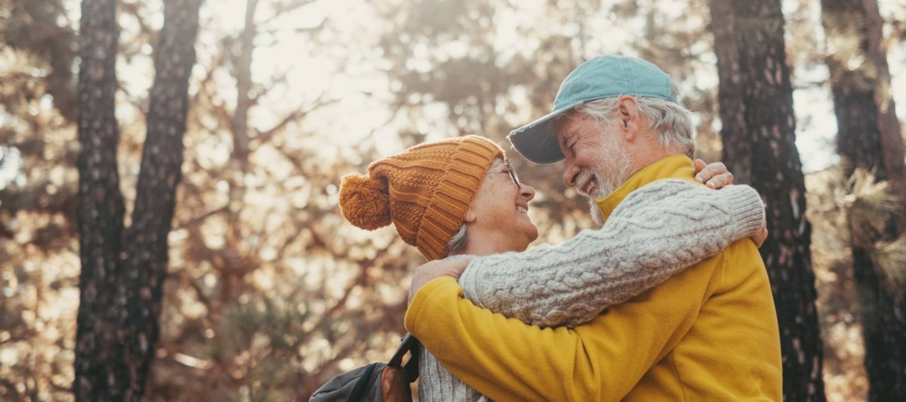 head shot portrait close up of old people smiling and enjoying looking each other in the forest of mountain