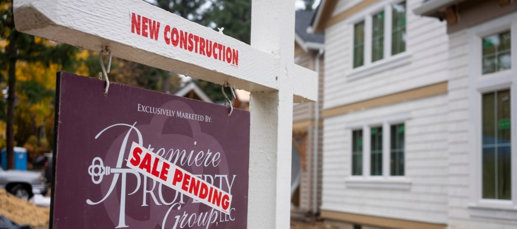 A Sale Pending sticker is seen on a real estate yard sign made by the Premiere Property Group outside a newly-constructed home.