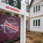 A Sale Pending sticker is seen on a real estate yard sign made by the Premiere Property Group outside a newly-constructed home.