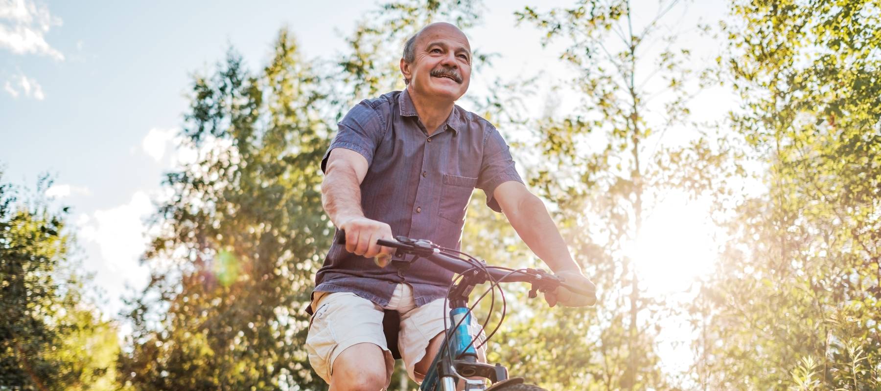 A gentleman riding a bicycle on a trail.
