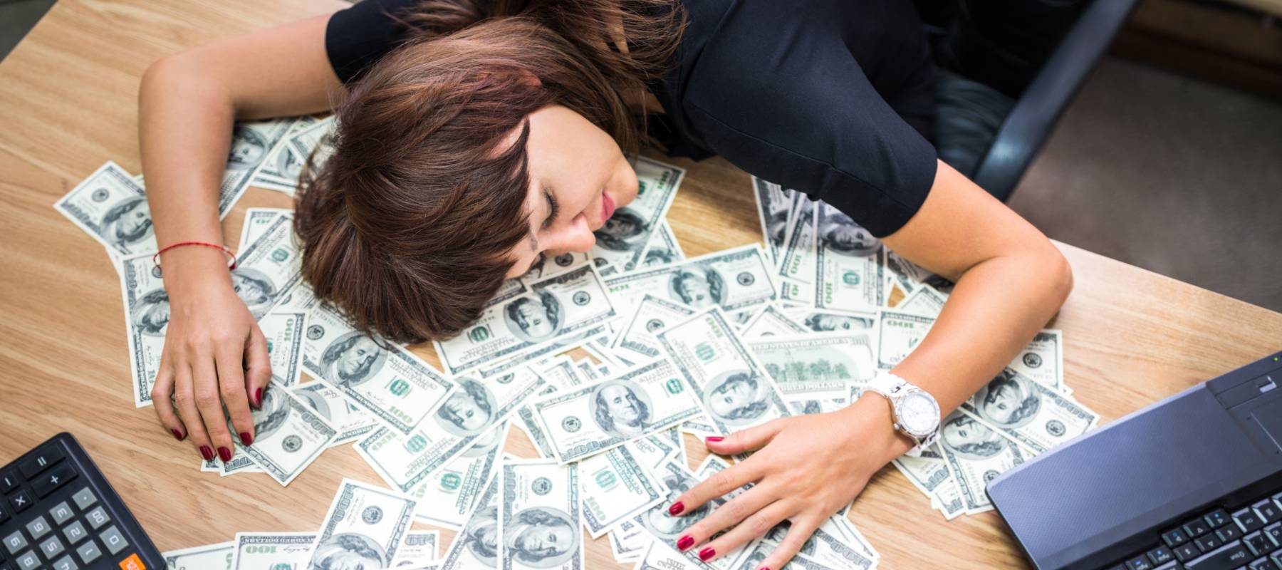 An exhausted young woman sleeps at her desk.
