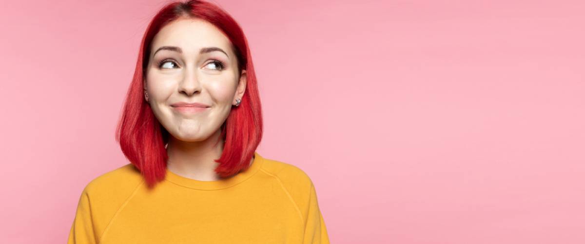 Young woman with short, bright red hair smiling