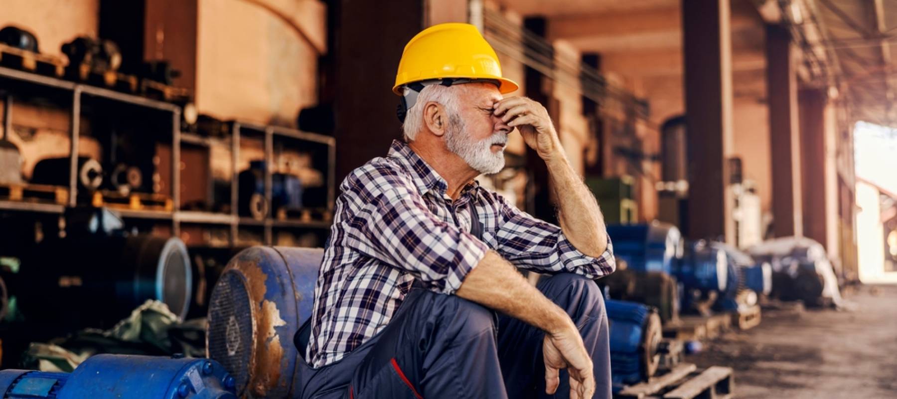 A worried senior factory worker