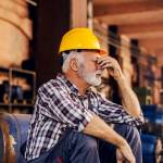 A worried senior factory worker