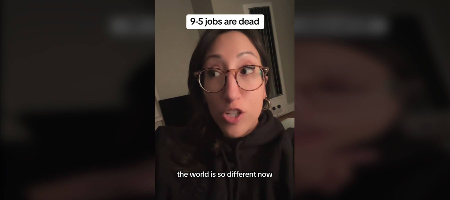 Woman holds camera looking at it, talking.