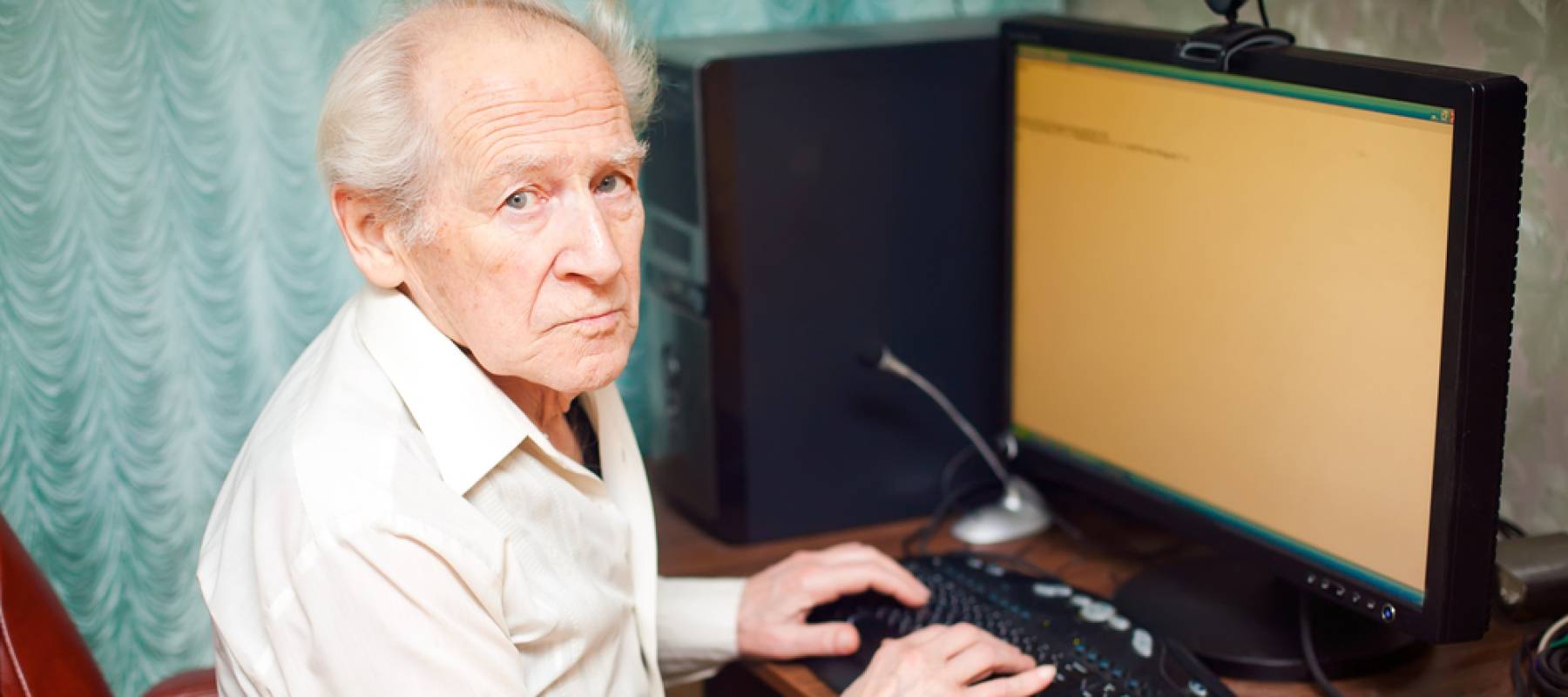 old man typing something on his computer