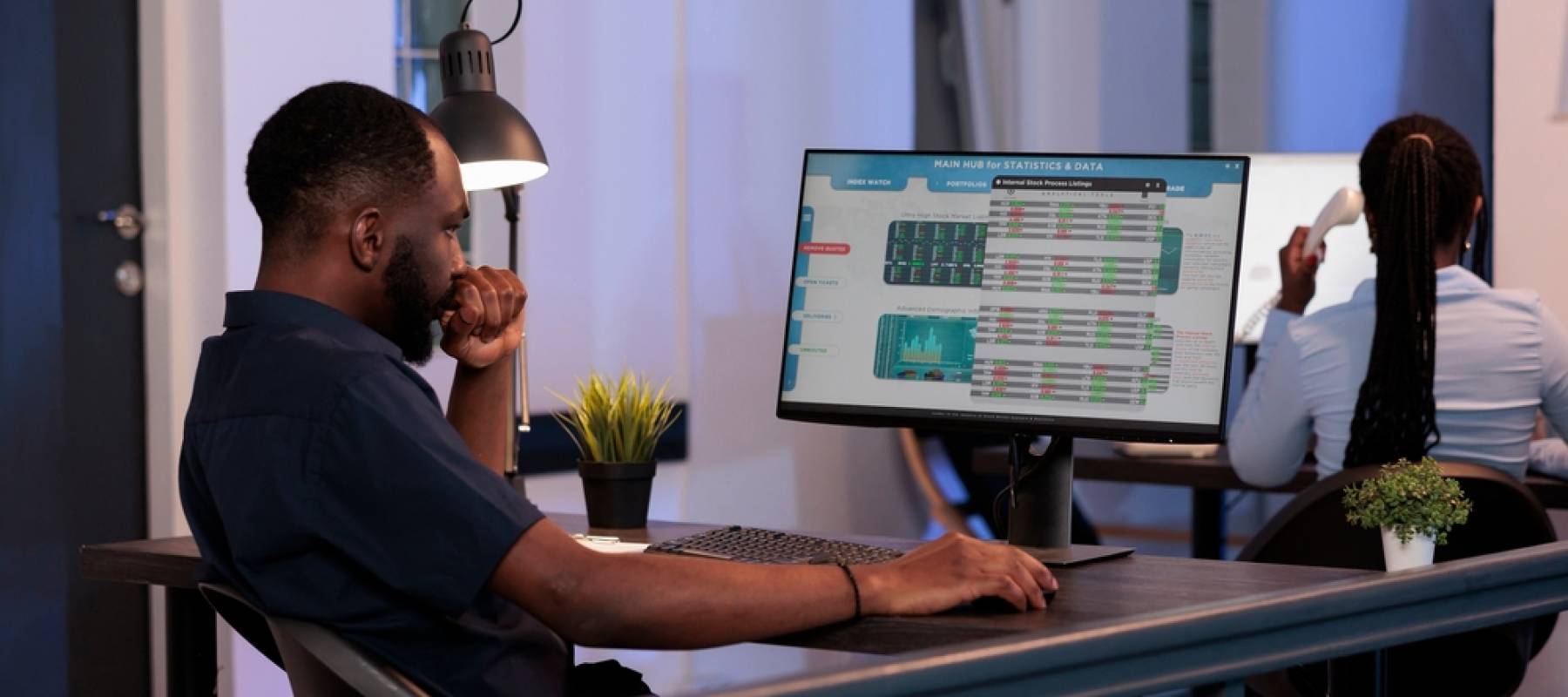 Man looking at computer screen with numbers.