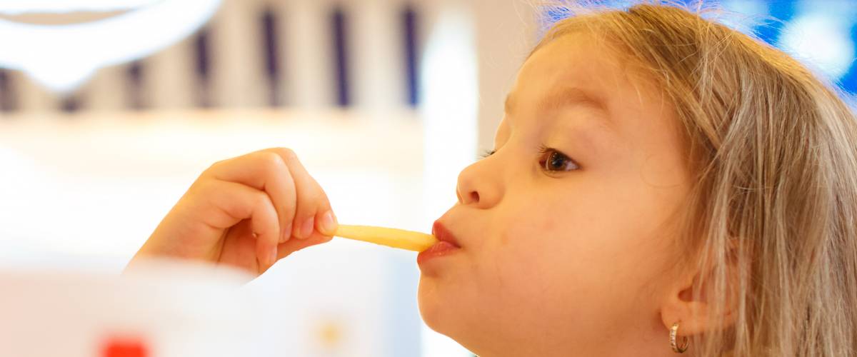 Little girl eats a french fry