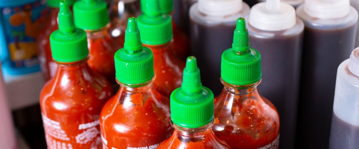 Multiple hot sauce bottles on counter