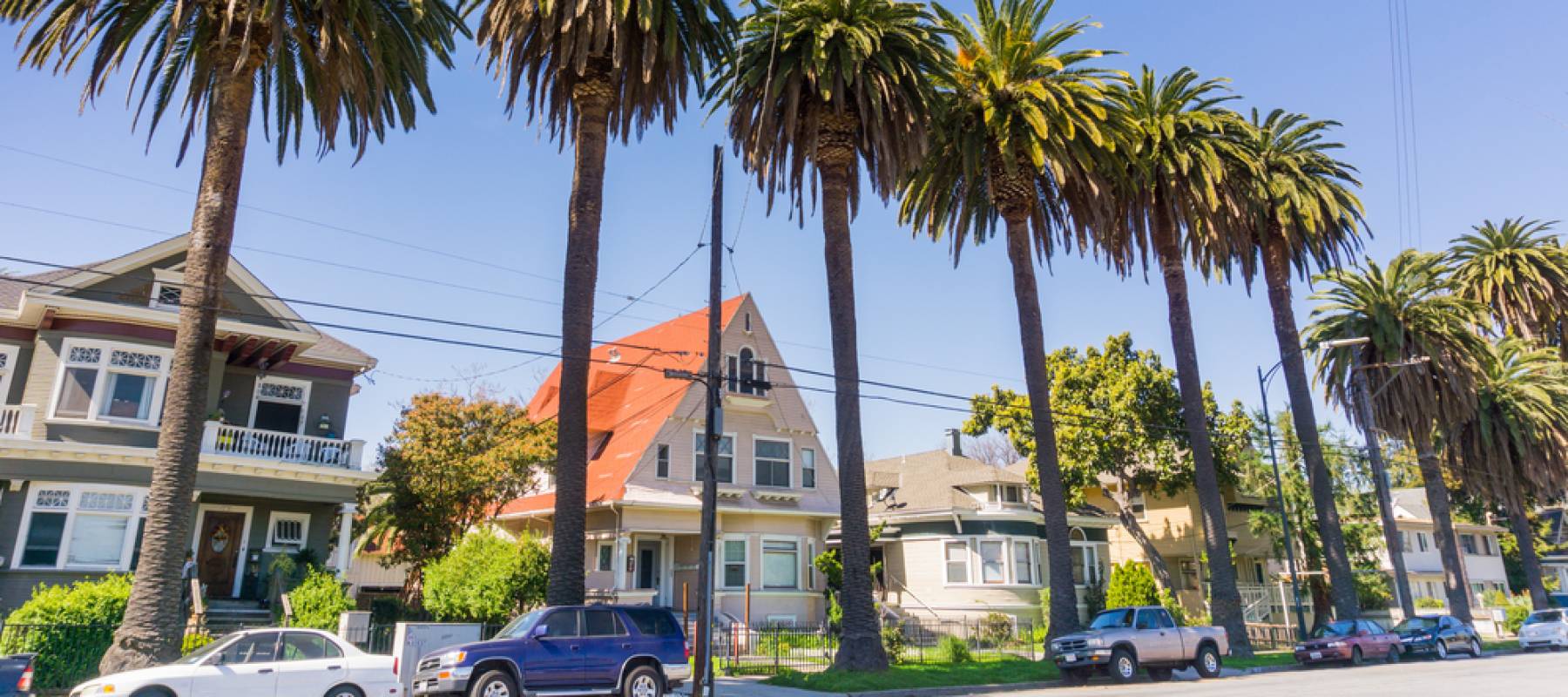 Old houses and palm trees on a street in downtown San Jose, California