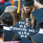 Young graduate teenager with question marks drawn over his head