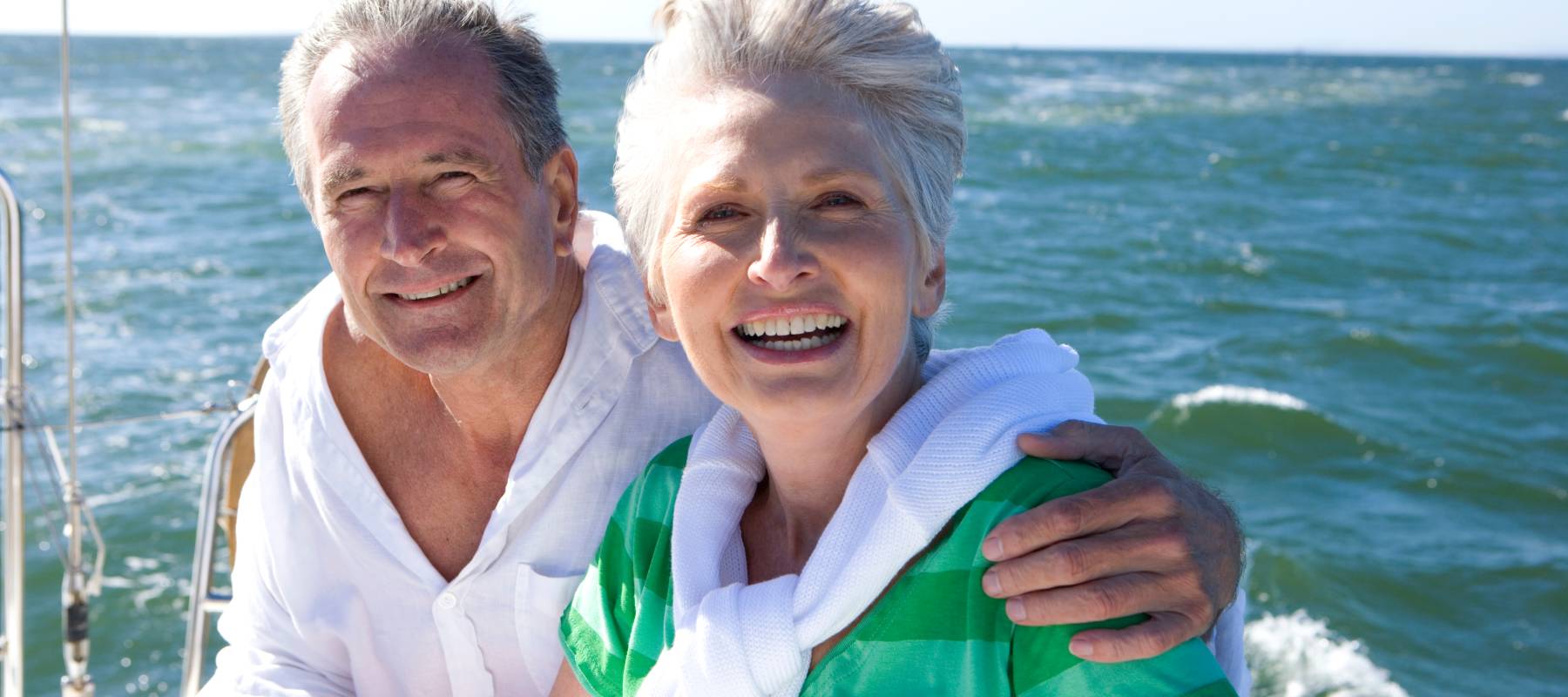 Smiling retired couple sailing a yacht.