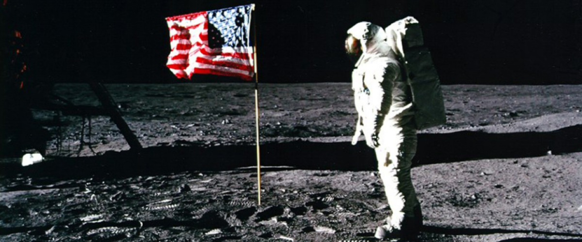 astronaut near the american flag that's just been planted on the moon