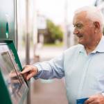 Senior using ATM machine to withdraw his money.